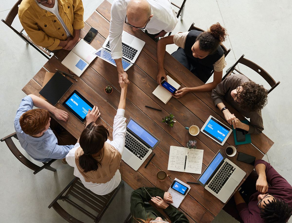 Team meeting around a table with laptops